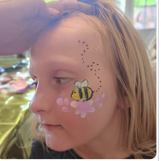 Bee face paint design near the eye